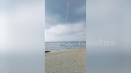 Needle-like waterspout tornado whirls off beach in Thailand