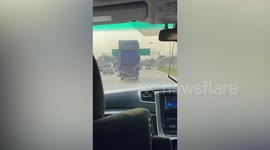 Pick-up truck carries enormous water while driving along highway
