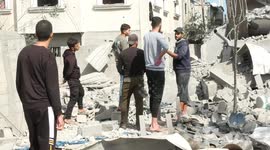 Palestinians inspect damages of building after Israeli airstrike in Deir al-Balah