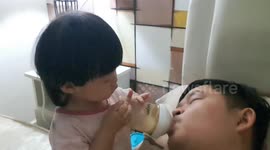 Adorable baby girl feeds remaining milk to her big baby daddy