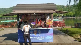 Tourists Walk Past A Kiosk In West Lake in Hangzhou, China