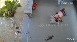 Snake slithers over to man while he naps on patio floor