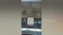 Truck passes under bridge by hair’s breadth