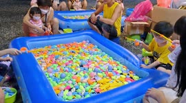 Parents and kids enjoy 'fishing' in pond