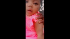 A cute baby reactions to not allowing her sister to sit down while carrying her