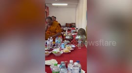 Chubby monkey joins Buddhist monks for lunch