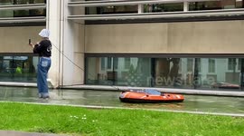 Pro-refugee activist with inflatable boat walks outside UK Home Office