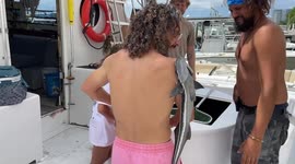 Father and son stick 'sharksucker' fish on their bodies in BIZARRE encounter