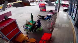 Gusts blow over sign outside shop as storm approaches in Thailand