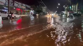Cars battle through flooded roads after torrential monsoon rains hit northeast Thailand