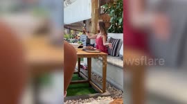 Young 'influencer' amuses tourists as she records a video-selfie of herself meditating