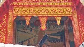 Wild honeybees 'displaced by fluctuating weather' build huge hives over temple entrance