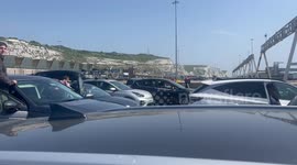 Motorists wait outside vehicles as half-term holidaymakers hit by travel chaos in Dover