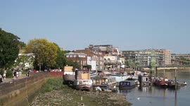 Upper Mall, Hammersmith, and Chiswick Mall in bright sunshine with the Thames in low tide and houseboats moored off Furnivall Gardens. 27th May 2023. London, UK.