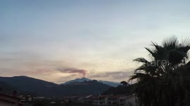 Black smoke spews out of Mount Etna volcano as sun sets