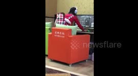 Mum carries baby in backpack so she can play computer games