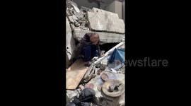 Palestinian antique collector Hazem Muhanna, 62, holds old banknotes as he sits amidst the rubble of his house in Gaza City, which was destroyed in an Israeli air strike during the latest Israel-Gaza conflict