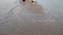 Locals take selfies on elusive river sandbar that only appears during low tide in Thailand