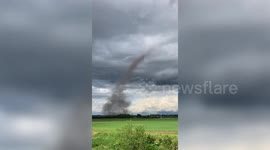 Dark dust devil tornado touches down close to airport in Japan