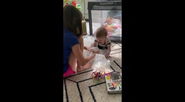 Sweet toddler giggles uncontrollably as his sister pops the packing bubbles