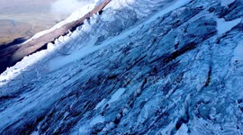 Toma aérea de volcán Cotopaxi con drone en el glaciar y valle