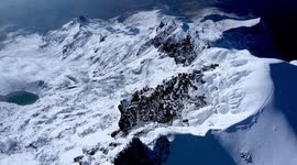 Toma aérea de la cumbre del volcán Iliniza Sur con drone en un día nevado y vista al valle y laguna