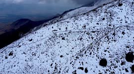 Toma aérea de alpinistas escalando el volcán Iliniza Norte con drone en un día nevado