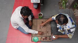 Two men play chess in the street in Cambodia