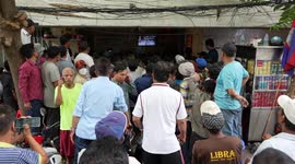 Dozens of men gather round tiny TV to watch boxing match in Cambodia