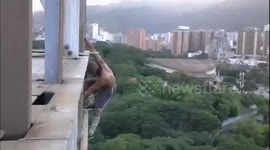 JAW-DROPPING images and video show an extreme sports athlete perform an exercise routine as he dangles from the edge of a sixty story high building with NO SAFETY equipment.