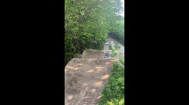 Cyclist nails jumps on dirt track whilst wild black bear watches on