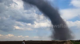 Excitement over huge landspout tornado over field in Stettler, AB Canada