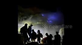A BLUE burning volcano has been captured in all its eerie glory as astounded tourists look on.
