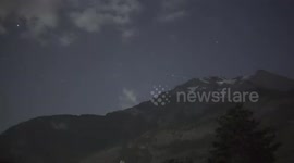 Newest SpaceX Starlink satellite train G2-10 surges from behind a mountaintop in the Swiss Alps