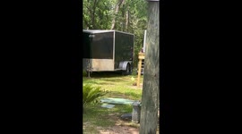 Man Mows Lawn While Carrying Cat in Backpack