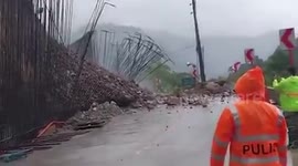 Landslide tumbles onto steel bars along mountain road during storm in the Philippines