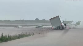 Huge flash flood on Texas highway leaves truck and other vehicles stuck partially submerged in gushing rainwater