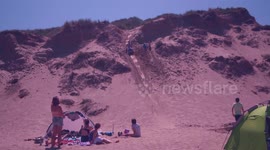Man sandboards on Cornwall dunes IGNORING 'keep clear' warning issued by Royal National Lifeboat Association