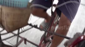 Riders use homemade pedal carts to transport passengers on this road in Bangkok