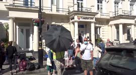 One fat troll woman uses huge umbrella to block migrants protest outside Comfort Inn Pimlico in Westminster