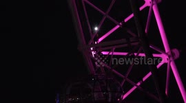 The Strawberry Full Moon rises over The London Eye as workmen on the London Eye check out the structure