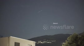 Starlink satellite train soars across night sky with Saturn in background