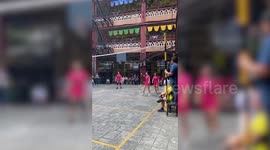 Player hits volleyball back to opponent with freak shot landing in basketball hoop