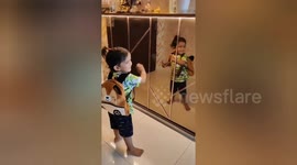 A cute little one year boy was watching himself in a mirror that's moment so lovely