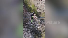 Fearless extreme slackliner zooms across wire on a skateboard