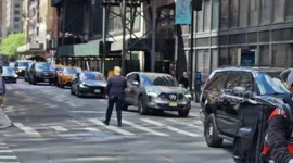 Donald Trump impersonator directing pedestrians across the street opposite Trump Tower in New York.
