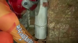 Rescue team free frightened kitten stuck in cement wall in Thailand