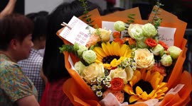 Mother waits with flowers as son concludes first day of University Entrance Exam