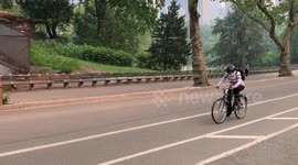 People wearing masks wile riding bicycles because NYC Under Wildfire Smoke from Canada fires