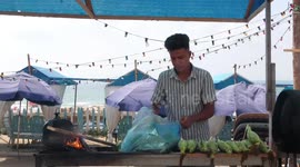Palestinian men prepare butter grilled corn for the customers on Gaza City's seaside